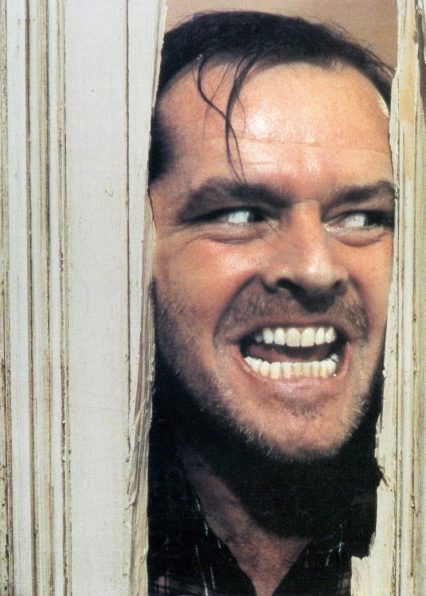 Jack Nicholson peering through axed in door in lobby card for the film 'The Shining', 1980. (Photo by Warner Brothers/Getty Images)